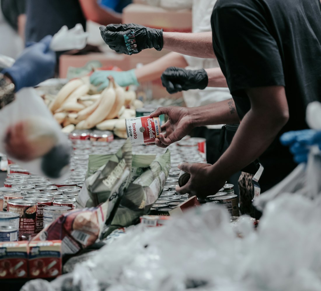 Volunteers sorting donated groceries at a long table