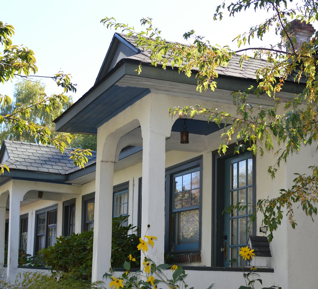 A row of small houses with porches and yellow flowers